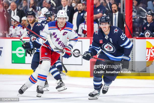 Jacob Trouba of the New York Rangers and Mark Scheifele of the Winnipeg Jets keep a eye on the play during second period action at the Canada Life...