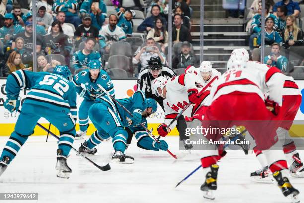 Tomas Hertl of the San Jose Sharks faces off against Martin Necas of the the Carolina Hurricanes at SAP Center on October 14, 2022 in San Jose,...