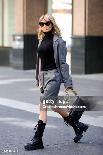 Influencer Gitta Banko, wearing a black turtleneck pullover by Liviana Conti, an asymmetrical grey blazer and matching grey bermuda shorts by...