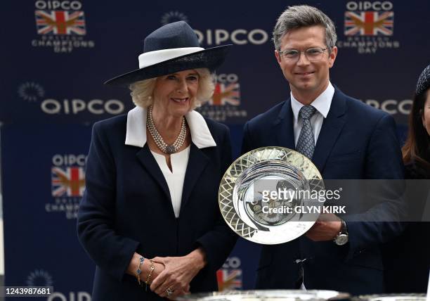 Britain's Camilla, Queen Consort poses for a photograph with trainer Roger Varian trainer of the winner of the Queen Elizabeth II Stakes on Qipco...