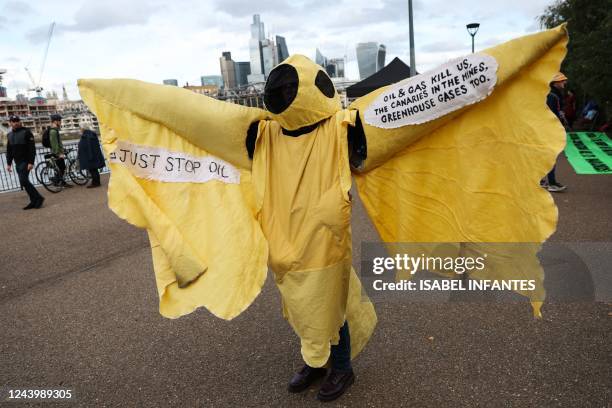 Dressed-up protester takes part in a gathering outside Tate Modern during a demonstration by the climate change protest group Extinction Rebellion,...