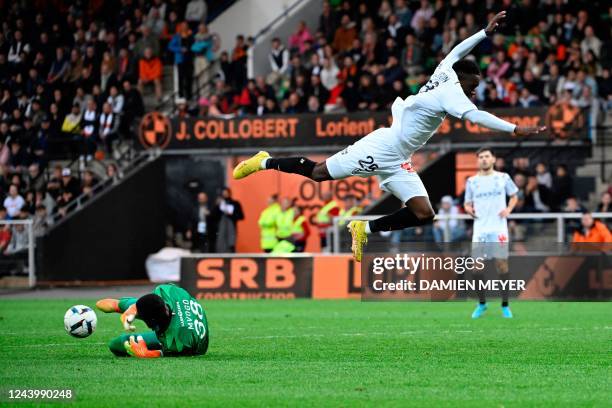 Lorient's Swiss goalkeeper Yvon Mvogo stops the ball facing Reims' English forward Folarin Balogun during the French L1 football match between FC...