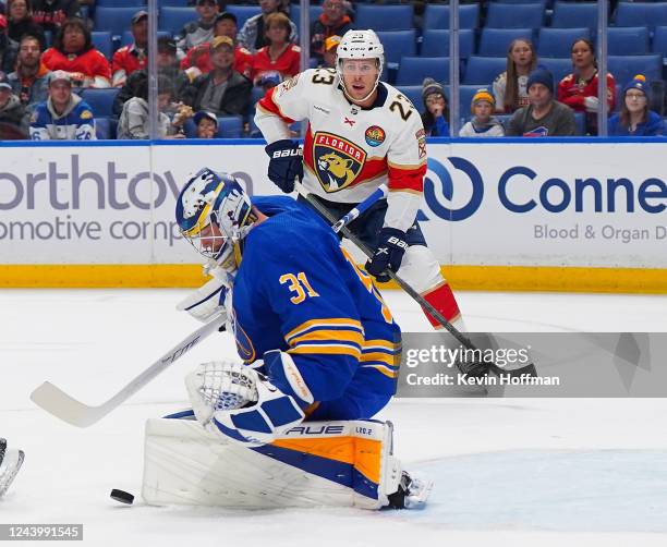 Eric Comrie of the Buffalo Sabres makes the save against Sam Bennett of the Florida Panthers as Carter Verhaeghe of the Florida Panthers looks on...