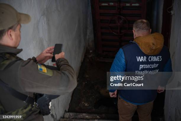 War crimes prosecutor views the body of a Ukrainian civilian during a search for evidence of war crimes in an underground air raid shelter that was...