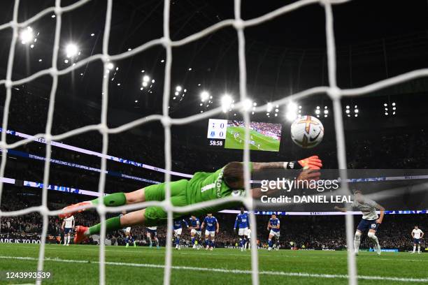 Tottenham Hotspur's English striker Harry Kane shoots a penalty kick past Everton's English goalkeeper Jordan Pickford and scores his team first goal...