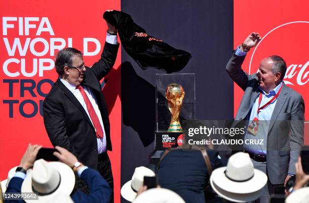 Mexico's Foreign Minister Marcelo Ebrard and the president of Coca Cola in Mexico, Roberto Mercade, unveil the FIFA World Cup trophy during the FIFA...