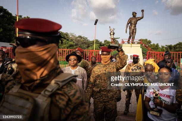 Captain Ibrahim Traore, Burkina Faso's new president, poses with the torch given by elders revolutionary during the ceremony for the 35th anniversary...