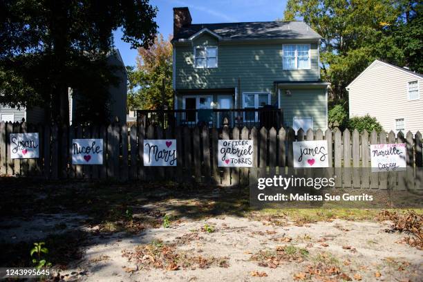 Signs with the names of victims are seen on a fence in the Hedingham neighborhood on October 15, 2022 in Raleigh, North Carolina. A vigil to honor...