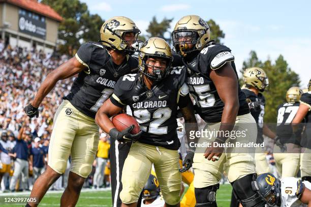 Running back Anthony Hankerson of the Colorado Buffaloes celebrates with offensive lineman Van Wells and wide receiver Montana Lemonious-Craig after...