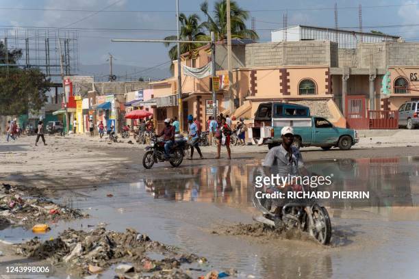 Men ride motorcycles in Port-au-Prince on October 15, 2022. - Canada is providing military personnel and security aid as Haiti faces a rise in gang...