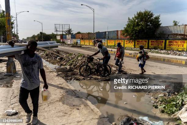 Peolple walk through the Tabrre neighborhood of Port-au-Prince on October 15, 2022. - Canada is providing military personnel and security aid as...