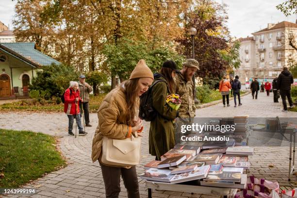 Evgeniya Poleno an actress takes time to check some books at Taras Schevchenko park, very close to the blast site, aftermath of Russian missile...