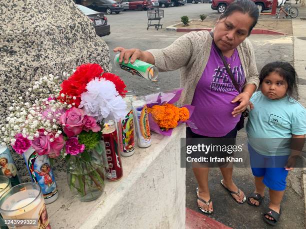 Pomona, CA Amelia Hernandez, left, with her 4-year-old daughter Nancy lights a candle at a makeshift memorial at the scene of last Friday night crash...