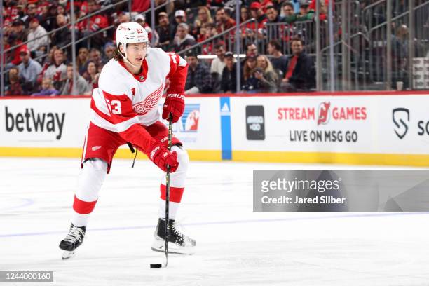 Moritz Seider of the Detroit Red Wings skates with the puck against the New Jersey Devils at the Prudential Center on October 15, 2022 in Newark, New...