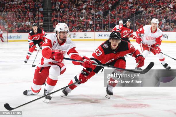 Dylan Larkin of the Detroit Red Wings skates with the puck against Ryan Graves of the New Jersey Devils at the Prudential Center on October 15, 2022...