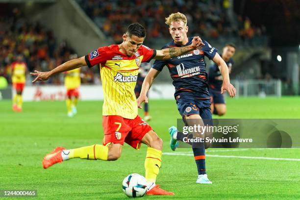 Florian Sotoca of RC Lens competes for the ball with Nicolas Louis Marcel Cozza of Montpellier during the Ligue 1 Uber Eats match between Lens and...