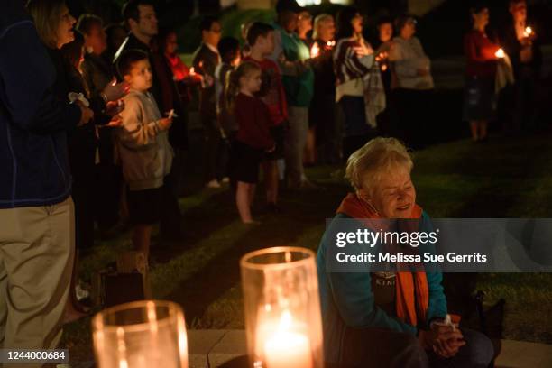 Woman sings with other community members at Beacon Baptist Church during a candle light vigil on October 15, 2022 in Raleigh, North Carolina. The...