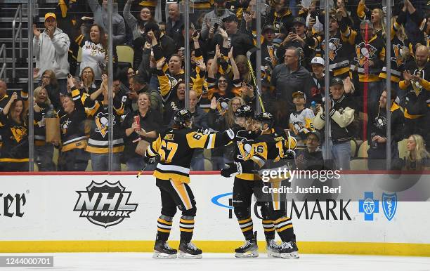 Danton Heinen of the Pittsburgh Penguins celebrates with Jason Zucker and Rickard Rakell after scoring a goal in the second period during the game...