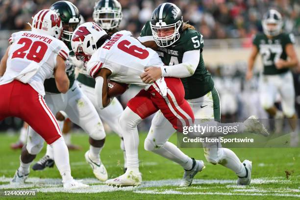 Michigan State Spartans long snapper Michael Donovan tackles Wisconsin Badgers punt returner Dean Engram during a college football game between the...