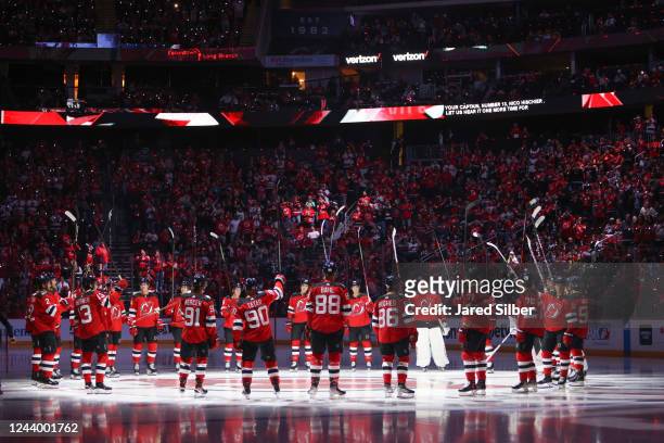 The 2022-2023 New Jersey Devils salute the crowd during pre game ceremonies prior to the game against the Detroit Red Wings at the Prudential Center...