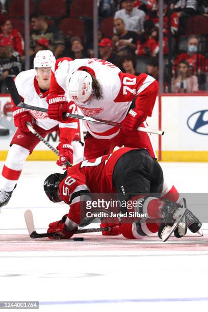 Oskar Sundqvist of the Detroit Red Wings battles for the puck against Erik Haula of the New Jersey Devils at the Prudential Center on October 15,...