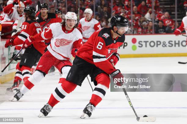 John Marino of the New Jersey Devils skates with the puck against the Detroit Red Wings at the Prudential Center during the home opener on October...