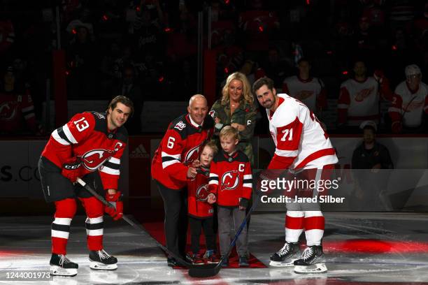 Recently retired defenseman Andy Greene drops the ceremonial puck to Nico Hischier of the New Jersey Devils and Dylan Larkin of the Detroit Red Wings...