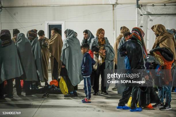 Migrants seen sheltering in the first aid camp. 64 irregular migrants, mainly from Afghanistan, Iran, Syria and Iraq, were helped by the Italian...