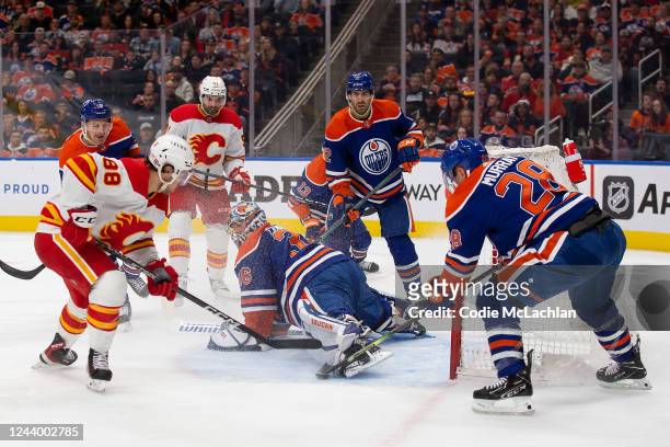 Goaltender Jack Campbell and Ryan Murray of the Edmonton Oilers can't stop Andrew Mangiapane of the Calgary Flames during the first period at Rogers...