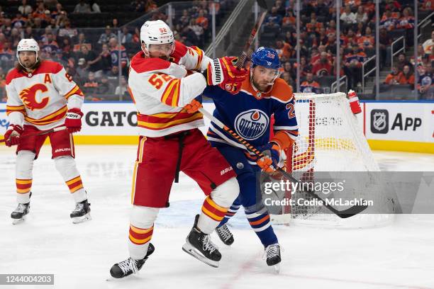 Leon Draisaitl of the Edmonton Oilers battles against MacKenzie Weegar of the Calgary Flames during the second period at Rogers Place on October 15,...