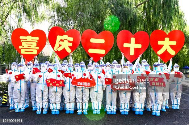 Community Party member volunteers and medical staff take a creative group photo of "Welcome to the 20th Congress of the Communist Party of China" in...