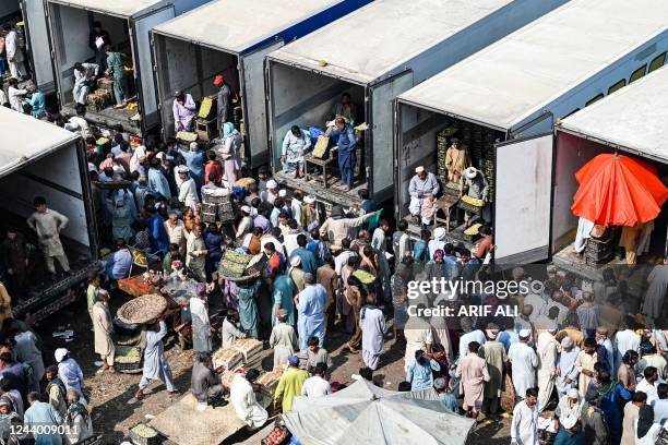 Traders, workers, and customers gather at a wholesale fruit market in Lahore on October 16 which also marks the World food day.