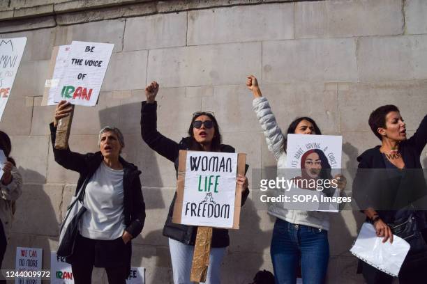 Protester holds a "Woman, life, freedom" placard in Trafalgar Square as protests for Mahsa Amini and freedom in Iran continue. Hundreds of people...