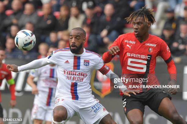 Lyon's French forward Alexandre Lacazette and Rennes' Cameroonian defender Christopher Wooh look on the ball during the French L1 football match...