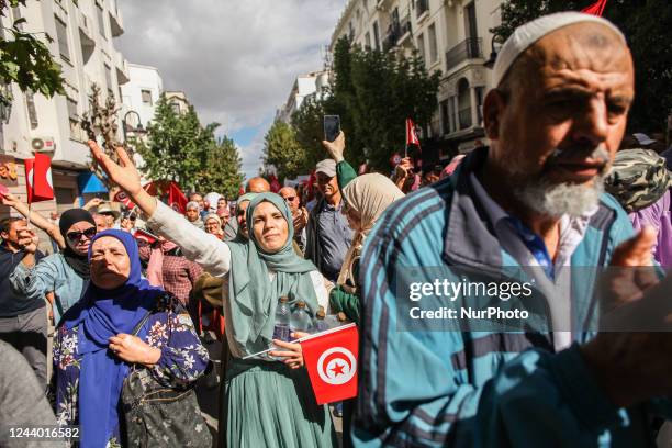 Female demonstrator holds the Tunisian flag as others chant slogans, during a demonstration held by the National Salvation Front , on the occasion of...