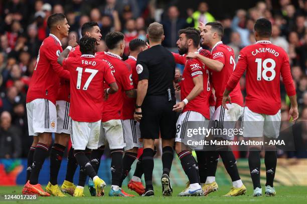 Players of Manchester United surround referee Craig Pawson to protest after he disallowed a goal scored by Cristiano Ronaldo during the Premier...