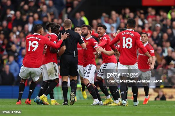 Players of Manchester United surround referee Craig Pawson to protest after he disallowed a goal scored by Cristiano Ronaldo during the Premier...