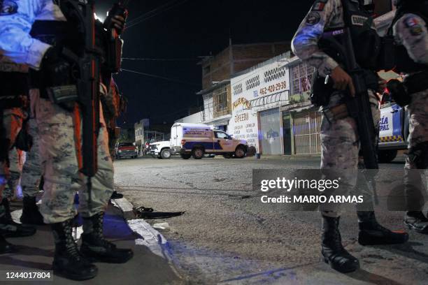 Members of the National Guard stand guard metres away from the bar where 12 people were killed by an armed group which opened fire on customers and...