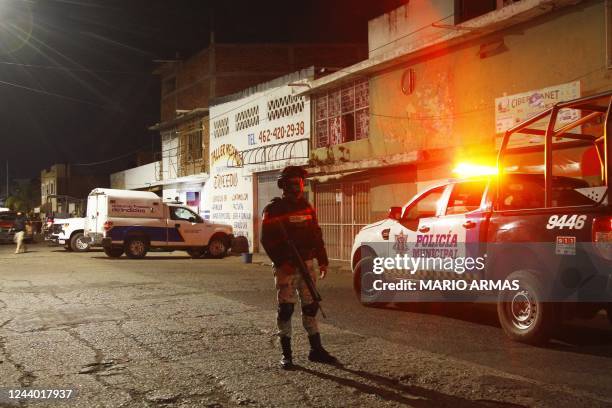 Members of the National Guard stand guard metres away from the bar where 12 people were killed by an armed group which opened fire on customers and...