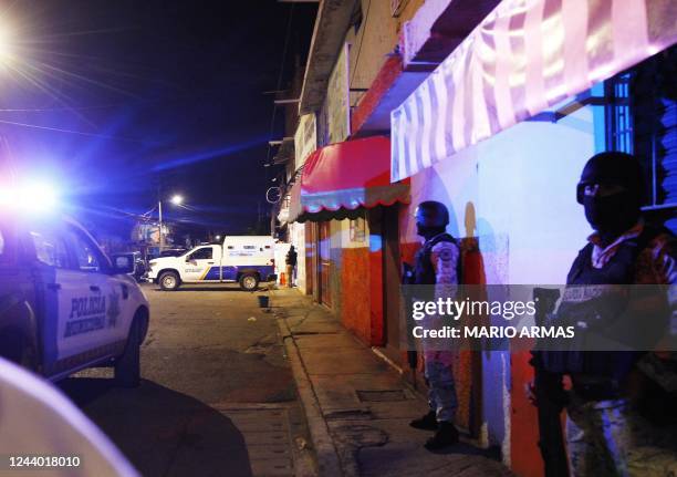 Members of the National Guard stand guard metres away from the bar where 12 people were killed by an armed group which opened fire on customers and...