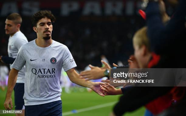 Paris Saint-Germain's Portuguese midfielder Vitinha cheers supporters ahead of the French L1 football match between Paris Saint-Germain and Olympique...