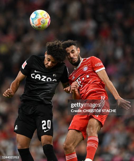 Freiburg's German forward Kevin Schade and Bayern Munich's Moroccan defender Noussair Mazraoui both jump to head the ballduring the German first...