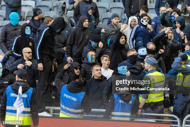 Supporters of Djurgardens IF attack AIK fans during an Allsvenskan match between Djurgardens IF and AIK at Tele2 Arena on October 16, 2022 in...