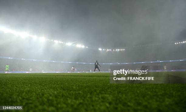 This photograph shows smoke during the French L1 football match between Paris Saint-Germain and Olympique de Marseille at the Parc des Princes...