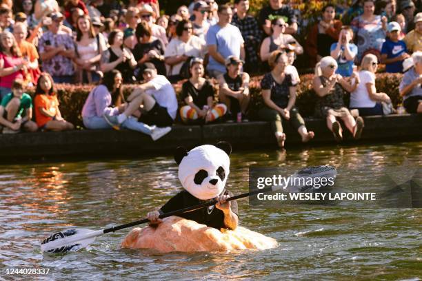 Jason Springs paddles to the finish line in a panda suit during the West Coast Giant Pumpkin Regatta in Tualatin, Oregon, on October 16, 2022. -...