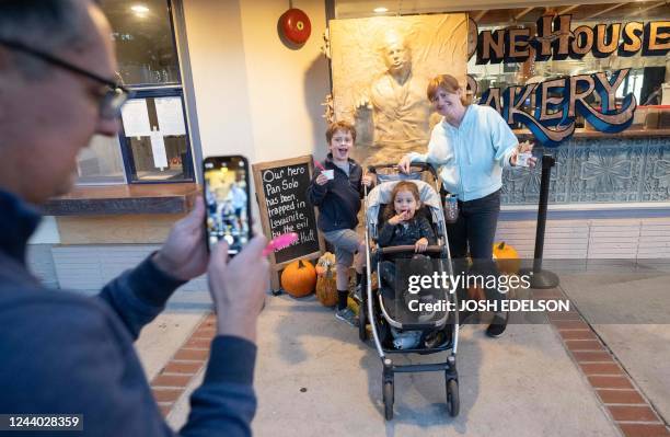 People take photos in front of "Pan Solo," a 6-foot-tall replica of Han Solo frozen in carbonite, made entirely of bread at One House Bakery in...