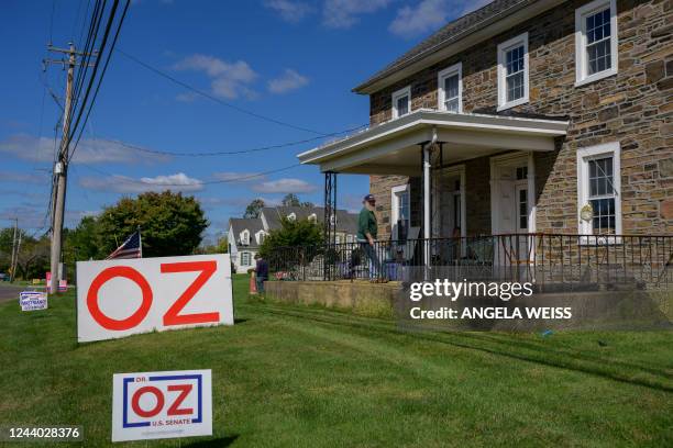 Bartender and Republican voter Randy Charlins sits on his porch with political campaign signs in his front yard near Doylestown, Pennsylvania on...