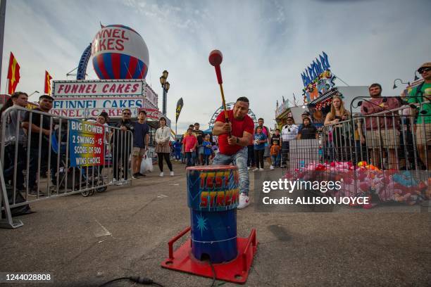 Man plays a strongman game at the North Carolina State Fair October 16 in Raleigh, North Carolina. - The North Carolina State Fair is held annually...