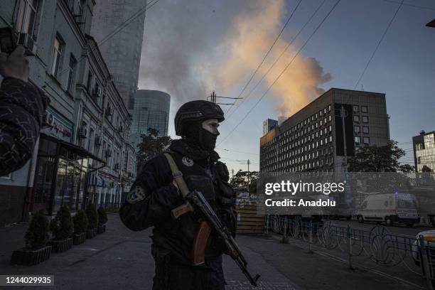 Ukrainian soldier stands guard in front of the building hit by the Russian forces in Kyiv, Ukraine on October 17, 2022. It was reported that two...