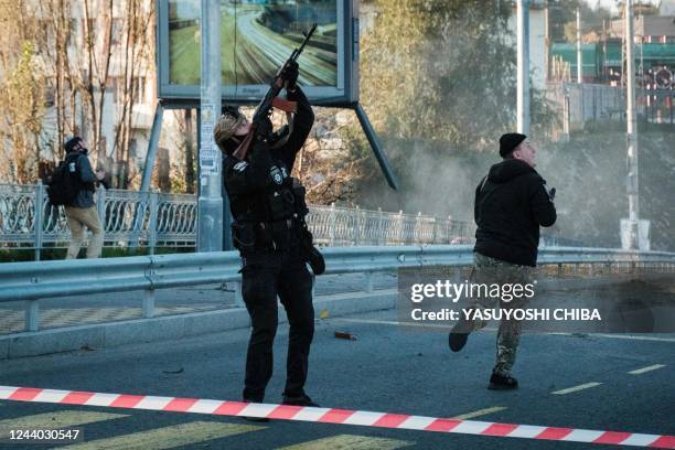 Police officer fires at a flying drone following attacks in Kyiv on October 17 amid the Russian invasion of Ukraine.